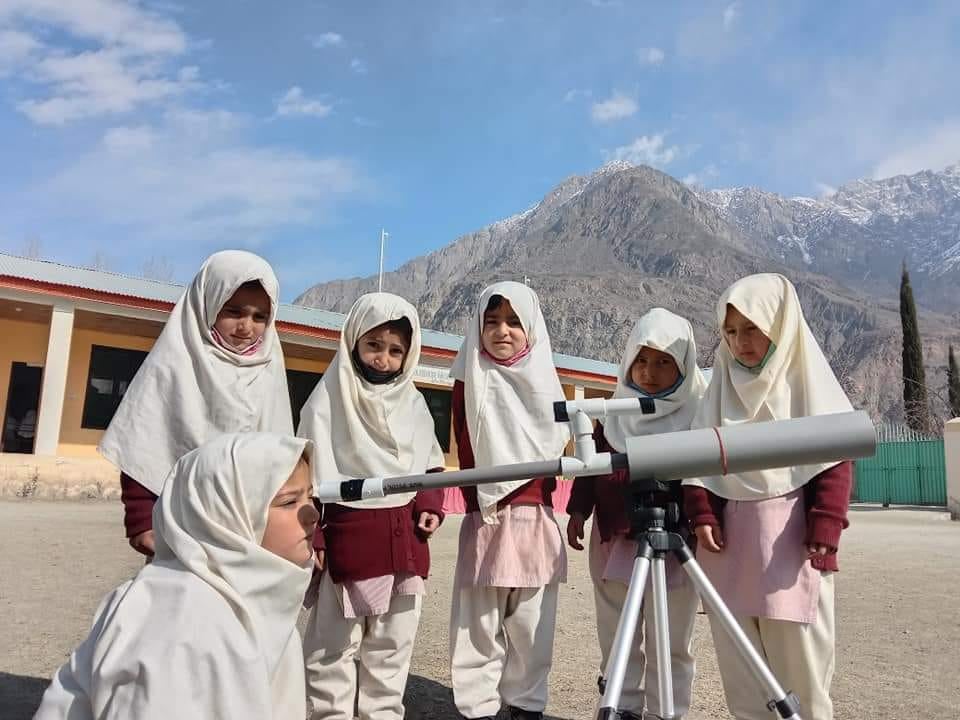 Girls in school using telescope